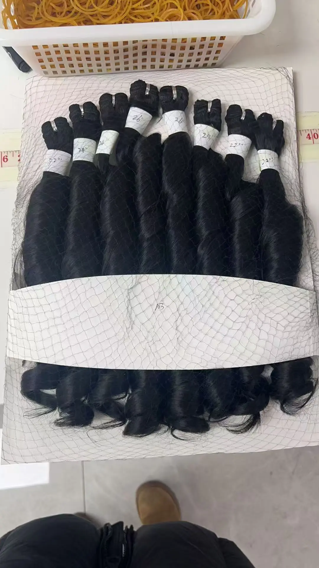 Wholesale Human Hair Wigs - bulk raw hair bundles laid on the floor for sorting and grading